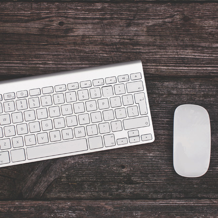 mouse and keyboard on a wooden backgroundの写真素材