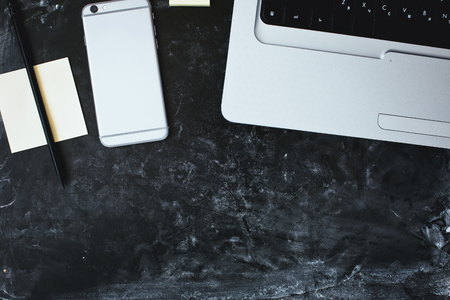Smartphone on the table, laptop and stickers on backgroundの写真素材