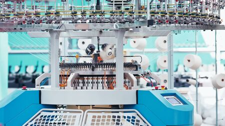 Textile Manufacturing. Knitted fabric. Textile factory in spinning production line and a rotating...