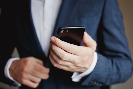 Businessman in suit using smartphone.の写真素材