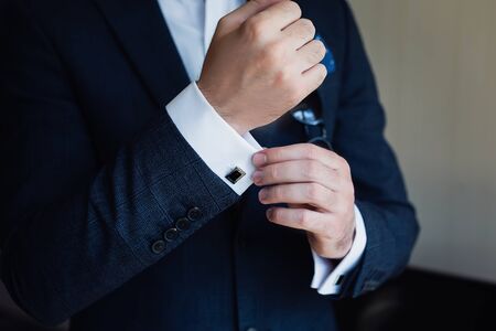 Close-up of a man in a tux fixing his cufflink.の写真素材