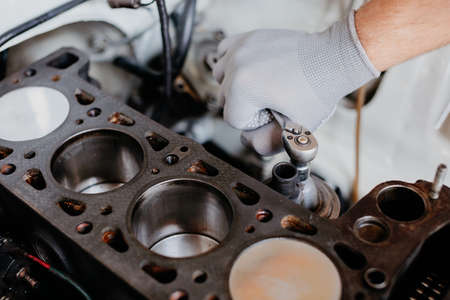 The mechanic replaces the timing chain on the four-cylinder engine.の写真素材