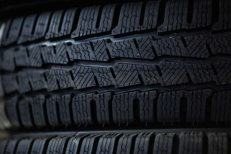 Tires close up. Black studdable winter tire profile. Car tires in a row.の写真素材