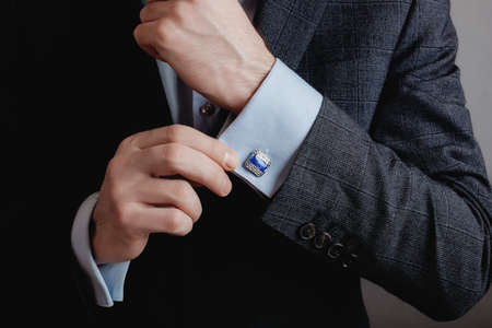 Close up of businessman wearing cufflinks. Elegant young fashion business man wearing suit.の写真素材