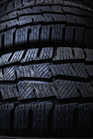 Tires close up. Black studdable winter tire profile. Car tires in a row.の写真素材