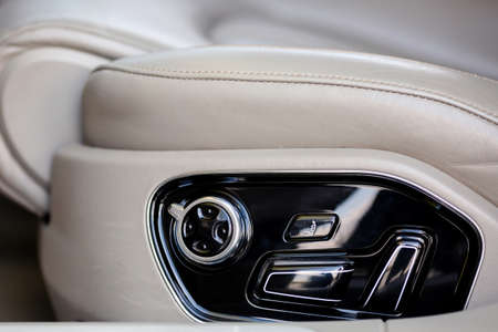 Buttons for adjusting seat position. White leather car seat and position adjustment button.の写真素材
