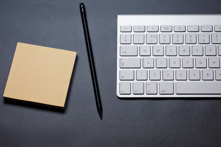 Office desk table with computer, supplies and coffee cup. Top view with copy spaceの写真素材