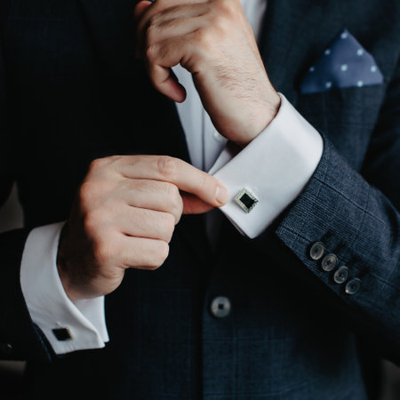 groom in a suit puts on cufflinks, close-up