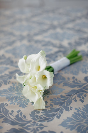Wedding bouquet of white calla lilies on the tableの写真素材
