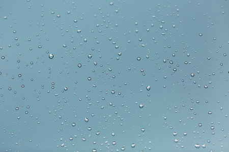rain drops on glass with blue background, shallow depth of field.の写真素材
