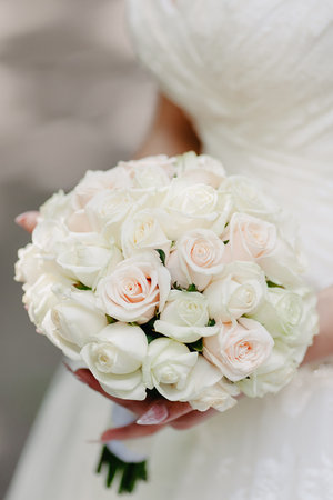 Wedding bouquet of white roses in the hands of the brideの写真素材