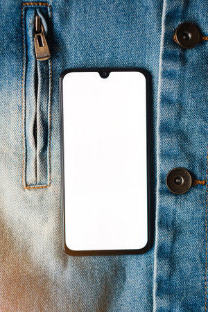 Smartphone with empty white screen on denim background.の写真素材