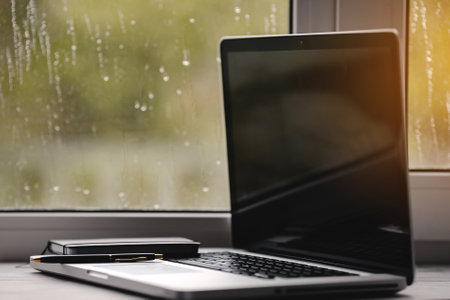 notebook with pen on window background with rain drops.