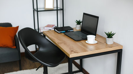 Working space with laptop and coffee cup on wooden table in living roomの写真素材