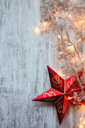 Christmas background with red star and garland on rustic wooden boardの写真素材