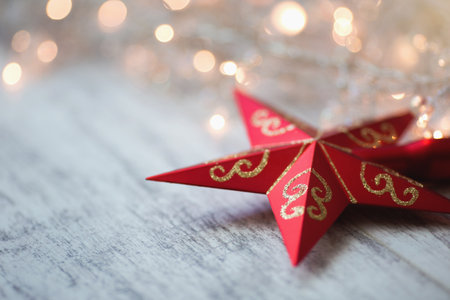 Christmas background with red star and bokeh lights on wooden boardの写真素材