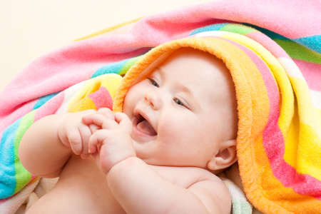 Adorable baby in colorful towel after bathの写真素材
