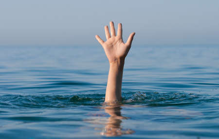 single hand of drowning man in sea asking for help