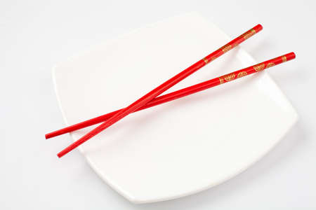White plate with red chopsticksの写真素材