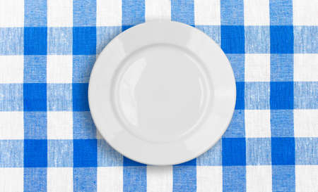 white plate on blue checked fabric tablecloth