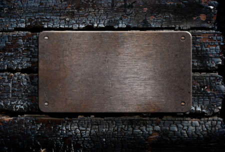 metal plate over burned wooden backgroundの写真素材