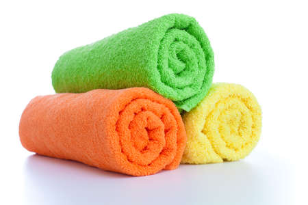 stack of fresh colorful towels rolls isolatedの写真素材