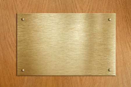 Wooden plaque with gold or brass plateの写真素材