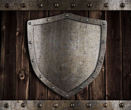 aged metal shield on wooden medieval gatesの写真素材