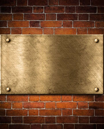 old golden or bronze plate on brick wallの写真素材