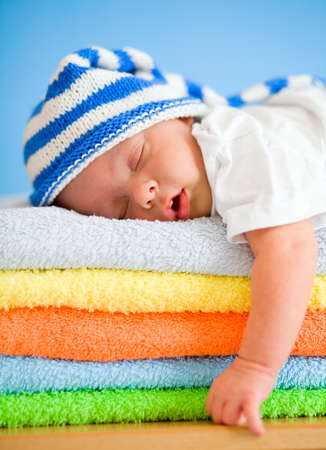 Sleeping baby on colorful towels stackの写真素材