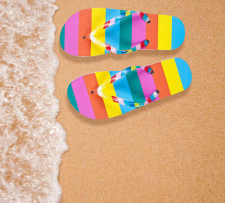 Colorful flipflop pair on sea beachの写真素材