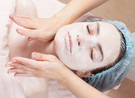 Beautiful woman with clear skin getting beauty treatment of her face at salonの写真素材