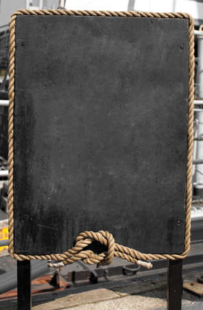Grunge blackboard with rope frame outdoor as a background for your messageの写真素材