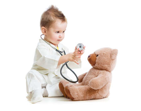 kid or child playing doctor with stethoscope and teddy bear isolated on whiteの写真素材