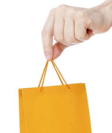 Hand close up with orange shopping bag isolated on whiteの写真素材