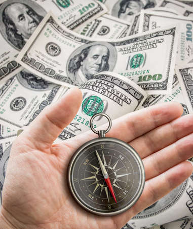 Hand with compass over hundred dollars. Finance concept.の写真素材