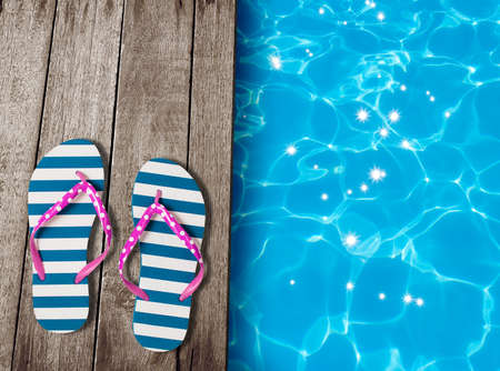 flip flop sandals on old wooden boards near swimming poolの写真素材