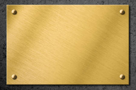 golden or brass metal plate or signboard on wall backgroundの写真素材