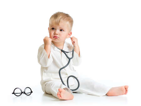 serious kid playing doctor with stethoscope isolatedの写真素材