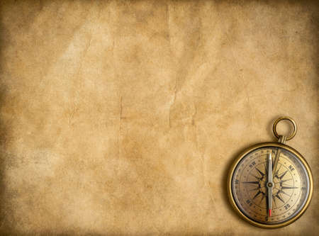 old golden compass with vintage map background