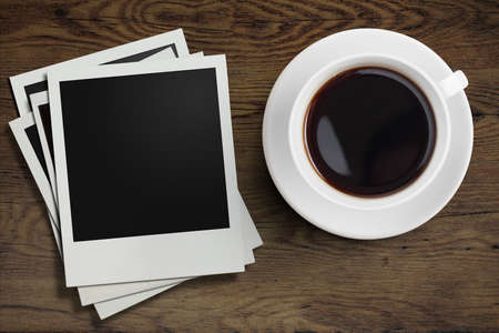coffee cup and polaroid photo frames on wooden table