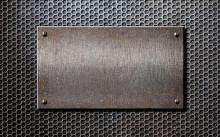old rusty metal plate over grid or grille backgroundの写真素材