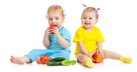 Kids eating fruits and vegetables isolatedの写真素材