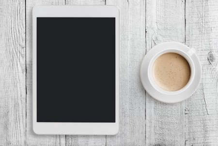 Tablet pc on table with coffee cup