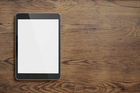 Black tablet pc on old wood table backgroundの写真素材