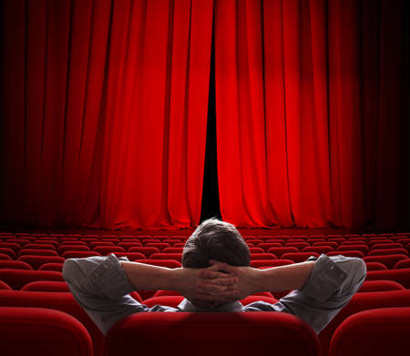 cinema screen red curtains slightly open for vip personの写真素材
