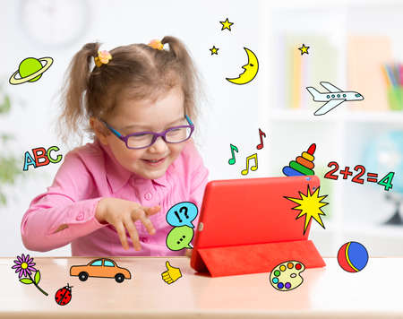 Kid with tablet computer in glasses. Early education.の写真素材