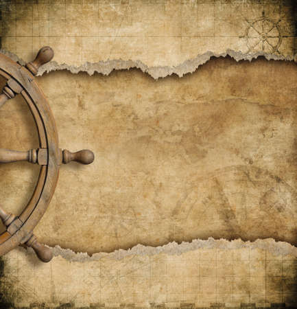 steering wheel and torn vintage nautical mapの写真素材