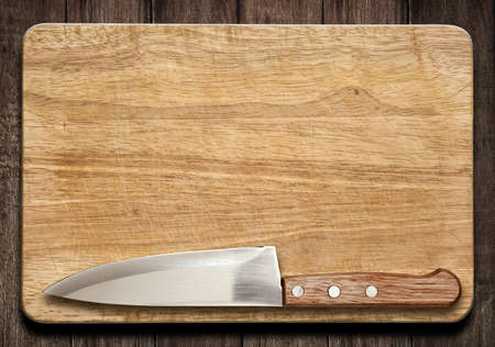 Cutting board and knife on old wood tableの写真素材