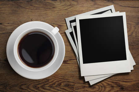 coffee cup and photo frames on tableの写真素材